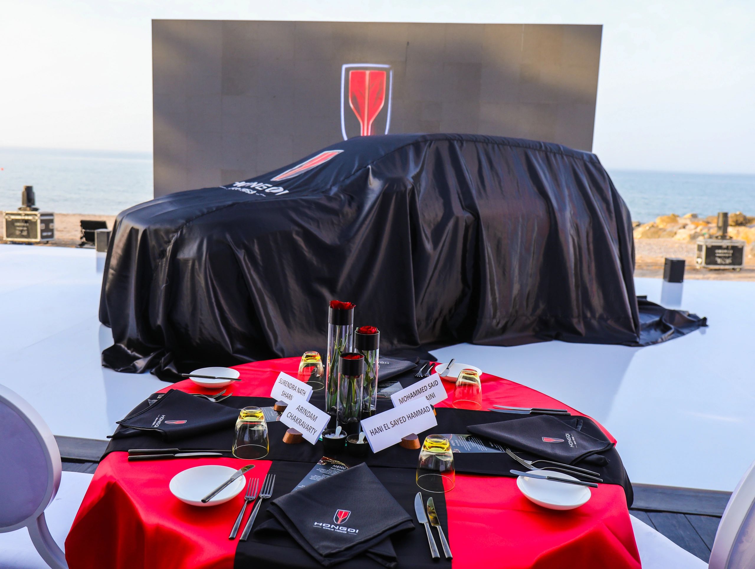 Hongqi-branded reveal cover and presentation screen beside the sea