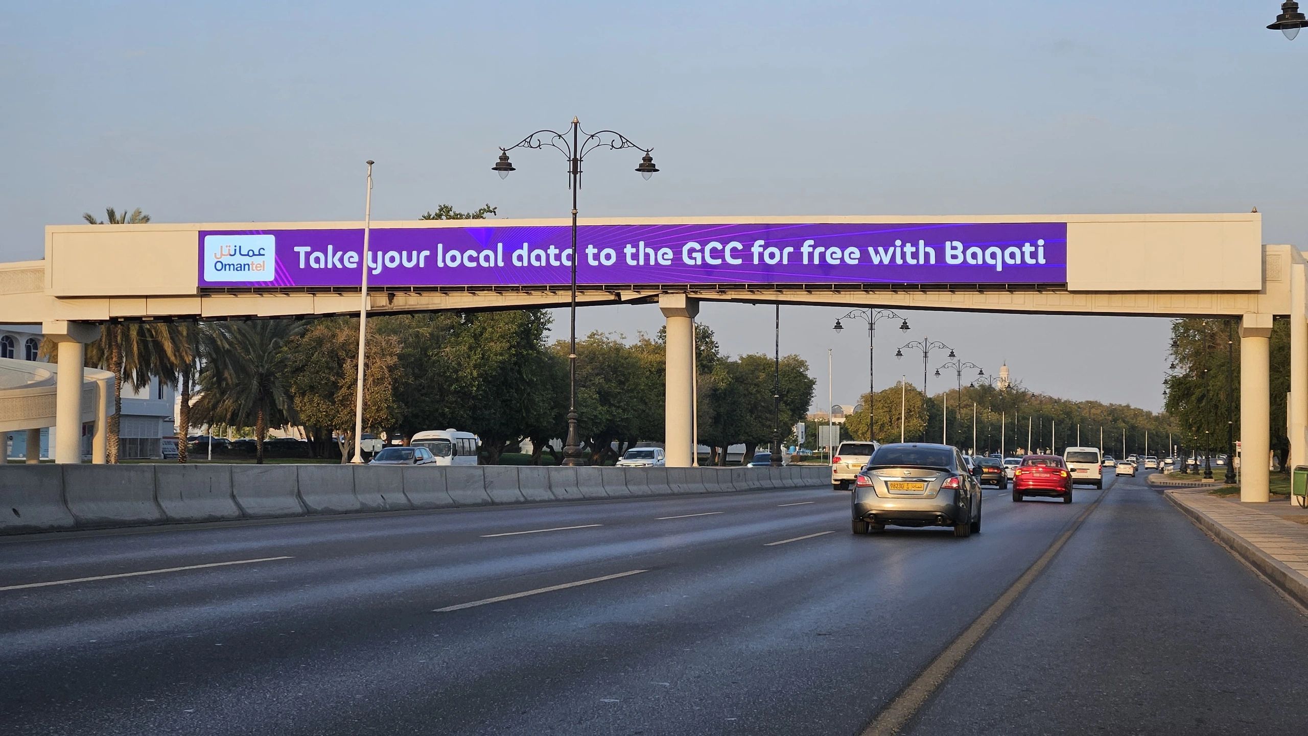 Bridge advertising across a roadway in Oman.
