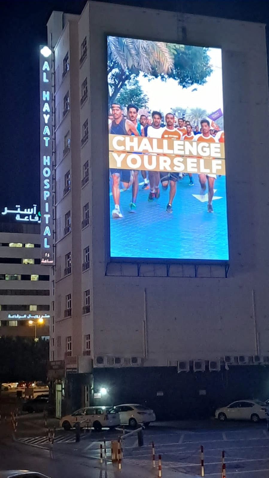 A large digital advertising screen on a building at night.